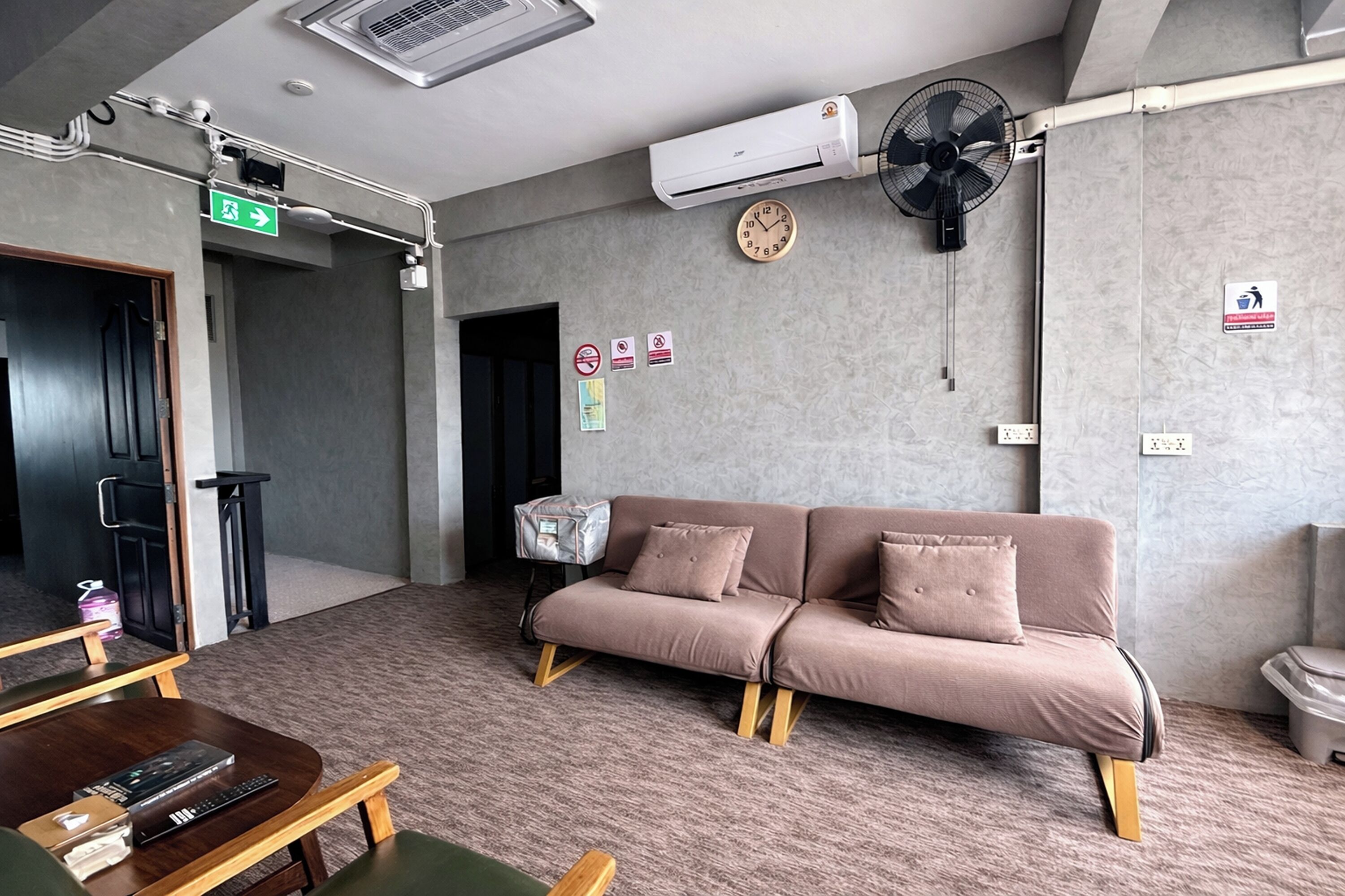 A modern room with a sofa, a small table, and a fan.