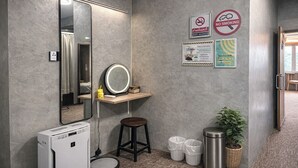 A bathroom with a mirror, stool, trash bins, and a small heater. - Nonoteru Chiang Mai Kamphaeng Din (Chiang Mai)