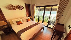 Un dormitorio con una cama grande, un escritorio y vistas a través de un ventanal corredera.