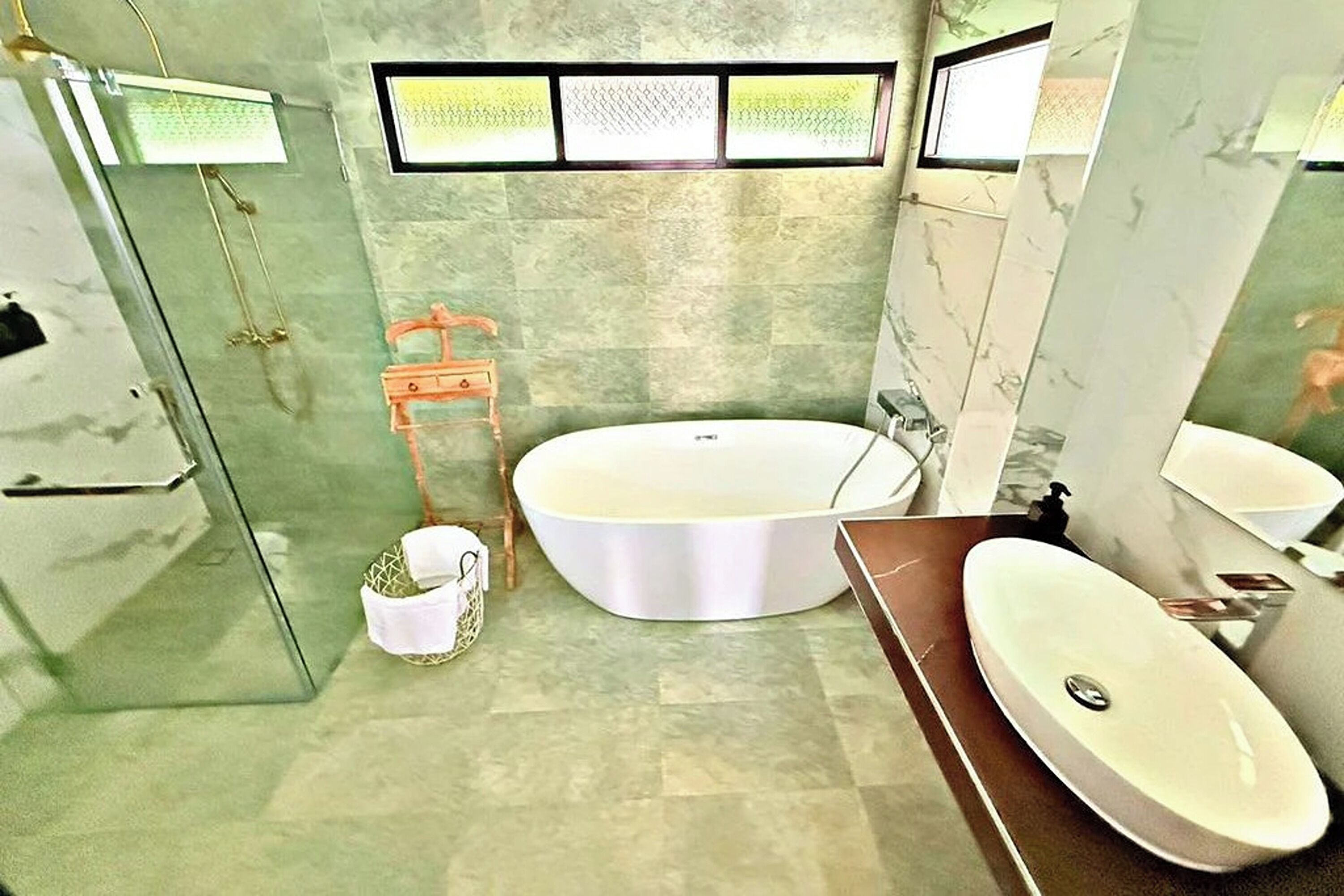 Une salle de bain avec une baignoire sur pieds, un lavabo séparé et un espace douche.