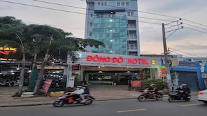 Ein Hotel mit auffälligem Schild, ein modernes Gebäude und eine Straße mit Motorrädern.
