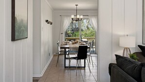 Zona pranzo con tavolo e sedie, un lampadario e vista dalla finestra.