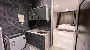Un baño moderno con salpicadero de mármol, lavabo empotrado y zona de aseo separada.