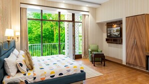 A bedroom with a bed, a chair, a TV, and a wardrobe. - asar Suites GK1 By Orion Hotels (New Delhi)