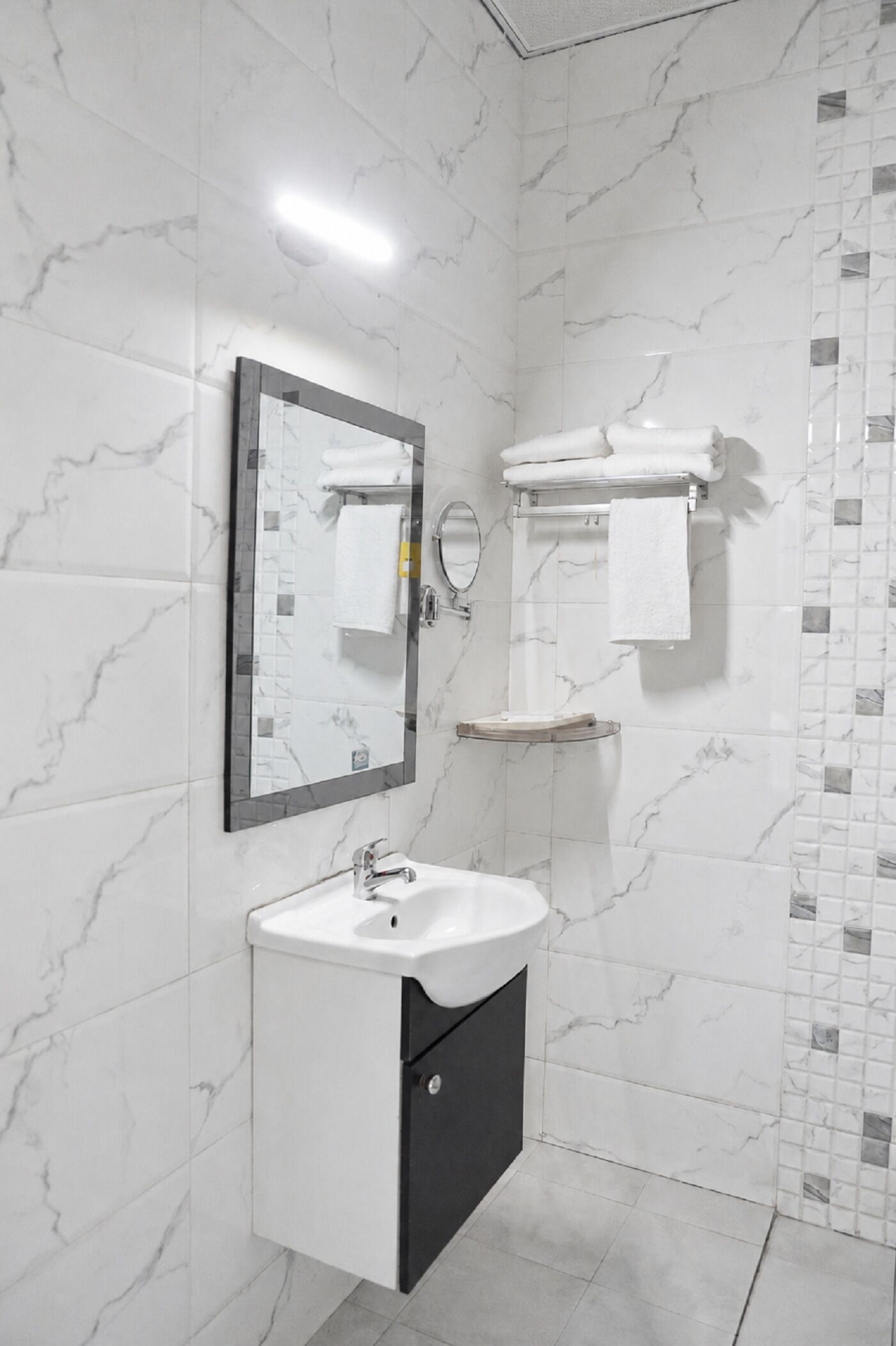 Ein Badezimmer mit Waschbecken, Spiegel und Handtuchhalter.