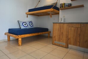 A room with a wooden bed, a lower bunk, a cabinet, and a shelf with books. - Apartment Sea View BB 3 guests in a family hotel (Perivolos)