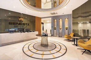 A modern lobby with a reception desk, a central table with flowers, and yellow chairs. - Modern & Central Apartment in Taksim w Pool, Gym, Balcony (İstanbul)