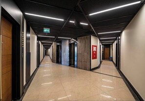 A corridor with a polished floor, a fire alarm, and a sign indicating the floor level. - Modern & Central Apartment in Taksim w Pool, Gym, Balcony (İstanbul)