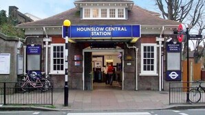 Estación Central de Hounslow con entrada despejada, un cartel y una bicicleta estacionada afuera.