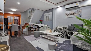 Een moderne woonkamer met een bank, salontafel en eethoek.