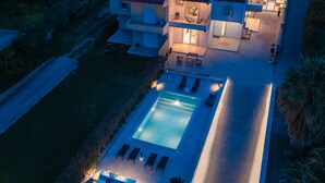 A multi-story house with a swimming pool, outdoor seating, and a well-lit patio area. - Yve Residence (Tsairi)