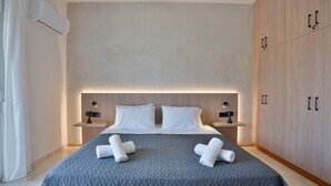 A modern hotel room with a large bed, bedside tables, a wardrobe, and an air conditioning unit. - Yve Residence (Tsairi)