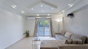 A modern living room with a sofa, a coffee table, and a potted plant. - Yve Residence (Tsairi)