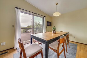 A dining area with a table, chairs, a potted plant, and a view through a sliding door to an outdoor balcony. - Steps to Great Food, Bus Routes & Light Rail (Seattle)