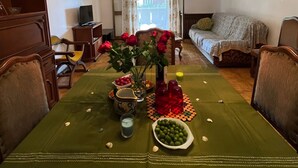 A dining area with a table set for two, a chandelier, and a view through a window. - Casa Genziana Sabbiadoro - Terrace - Parking - Air conditioning (Lignano Sabbiadoro)