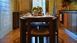 A kitchen with a dining table, chairs, a hanging light fixture, and a window. - Casa Genziana Sabbiadoro - Terrace - Parking - Air conditioning (Lignano Sabbiadoro)