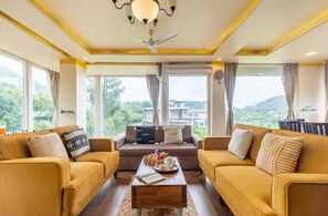 A spacious living room with a sofa set, a coffee table, and a ceiling fan. - Celestial Rhapsody 3 BR, Naukuchiatal (Dungsil Malla)