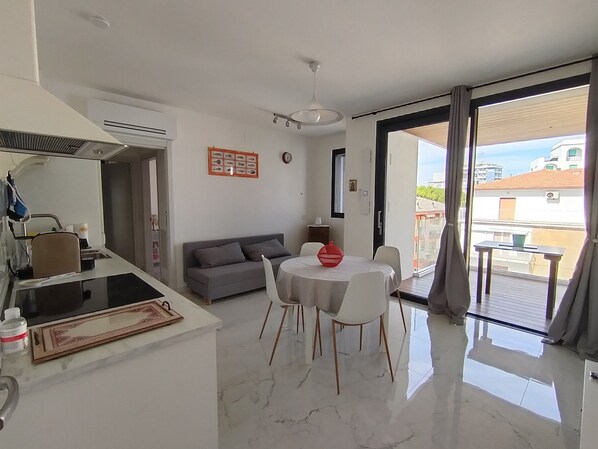 A modern living space with a kitchen, dining area, and a balcony. - Holiday Home 'Sun Max - Near The Sea' with Sea View, Wi-Fi and Air Conditioning (San Benedetto del Tronto)