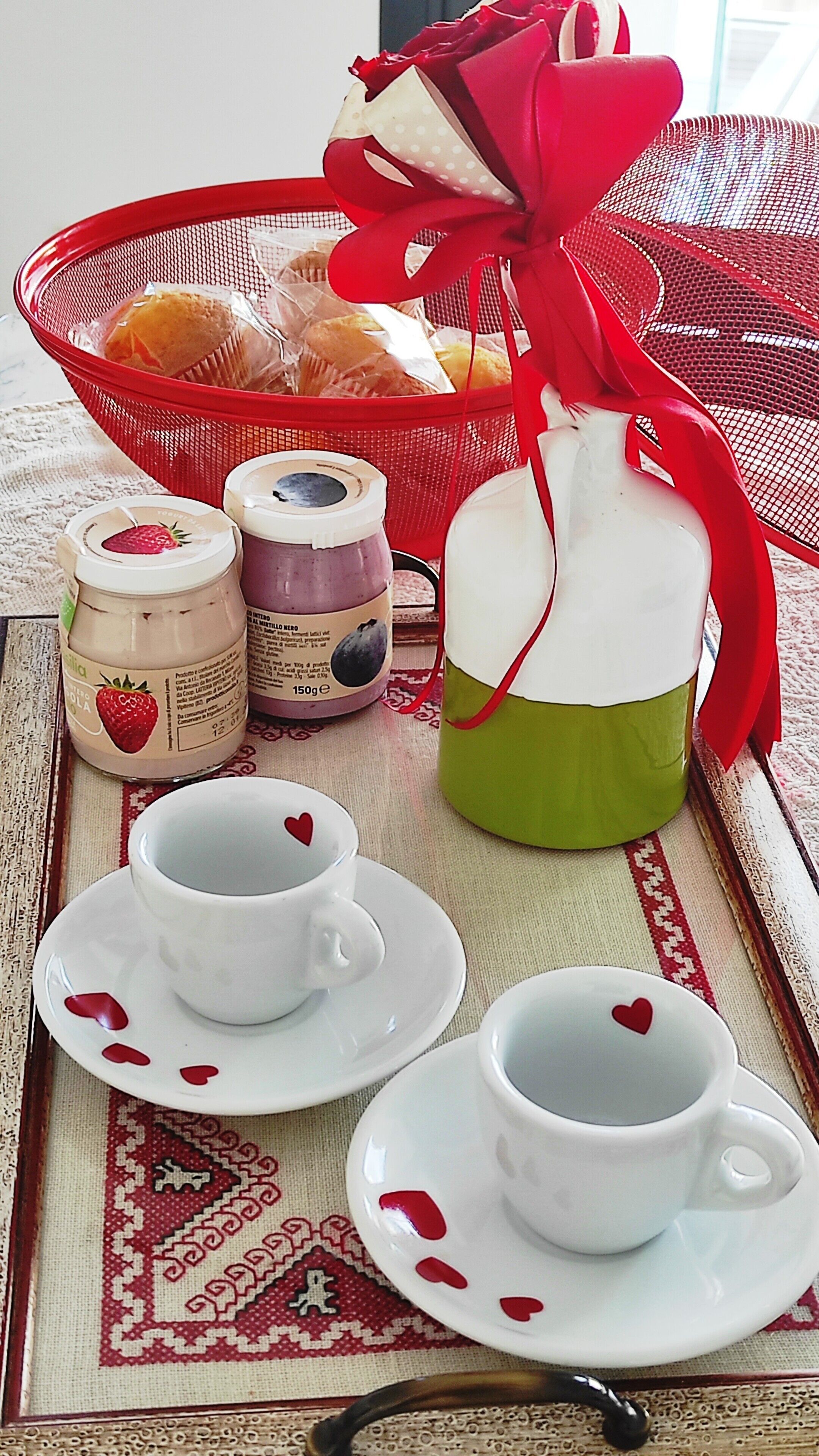 Un plateau avec deux tasses, une carafe et des pots de confiture.