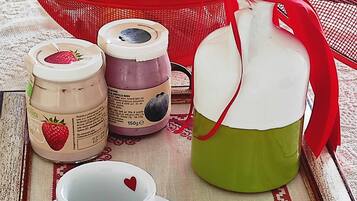 Un plateau avec deux tasses, une carafe et des pots de confiture.