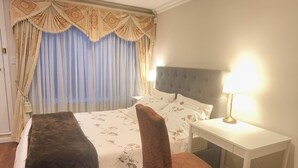 A hotel room with a bed, bedside table, lamp, and a small bench. - Sunshine Home Vancouver Near UBC/DT/YVR  Family-sized Studio (Vancouver)