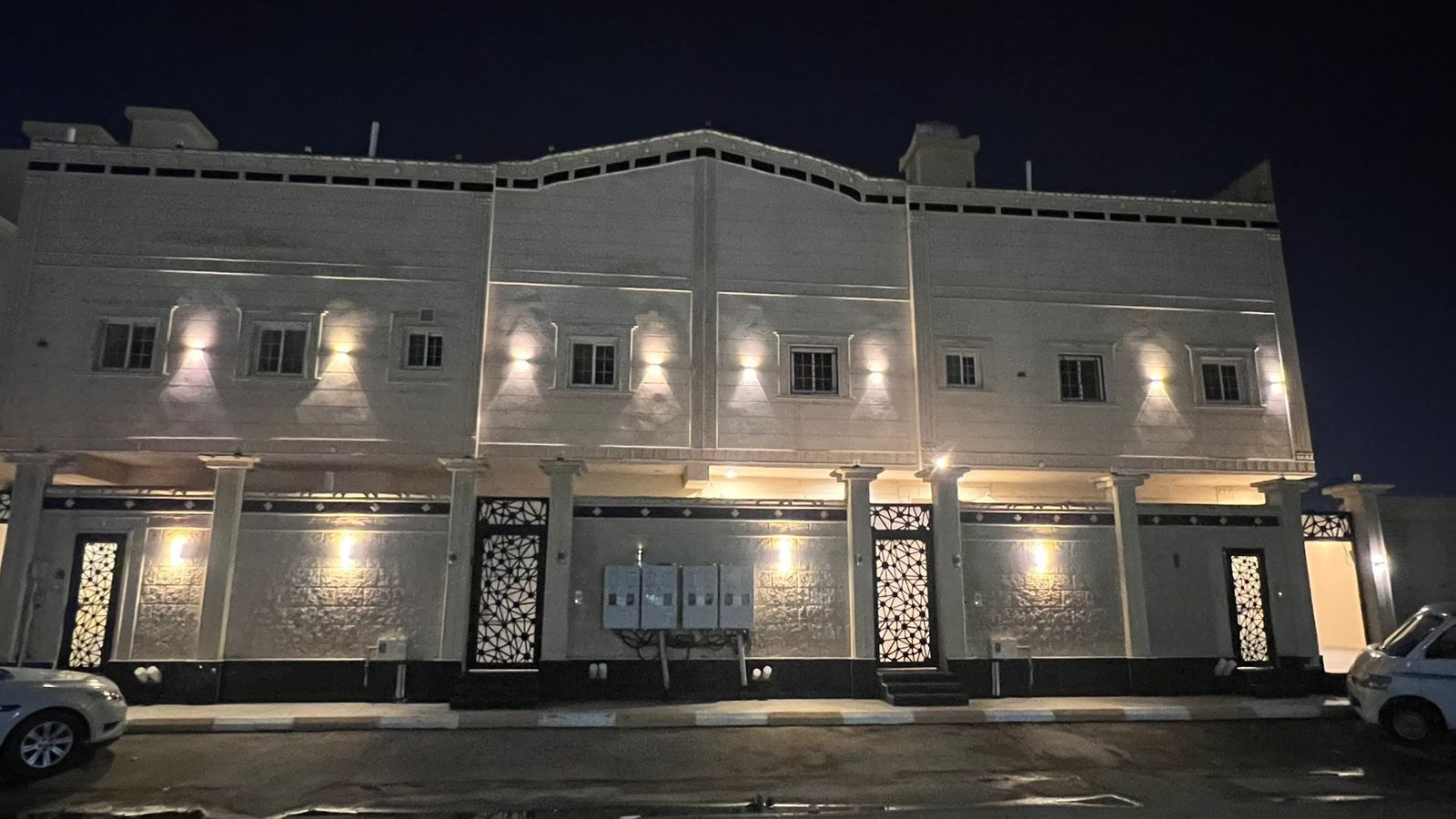 A multi-story building with illuminated windows and decorative gates, likely a hotel or office building.