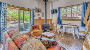 A cozy living room with a sofa, a table, a fireplace, and a TV. - Great for Couples! Studio Casita in Ruidoso (Ruidoso)