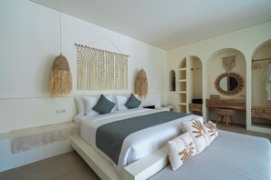 A modern bedroom with a large bed, a wall-mounted macrame piece, and a round mirror. - Velin Villa (Canggu)