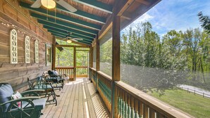 A wooden deck with outdoor seating, a view of trees, and a covered area with a ceiling fan. - Hike, Bike, Tubing, Whitewater Rafting! Saluda Gem (Saluda)