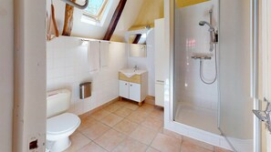 Une salle de bain avec des toilettes, un lavabo et une douche.