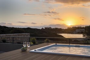 A rooftop terrace with a hot tub, two glasses of white wine, and a bowl of apples. - Aeora Villa, Shoreline Getaway (Chania)