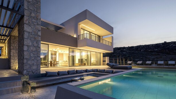 Een modern huis met een zwembad, een stenen pilaar en een terras.
