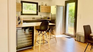 Una cucina moderna con un piano di lavoro in legno, lavastoviglie integrata e un'ampia finestra.