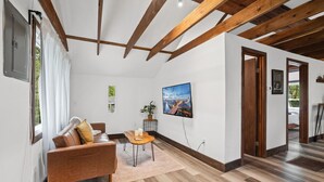 En moderne stue med sofa, lille bord og et billede på væggen.