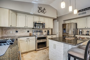 A kitchen with white cabinetry, a granite countertop, stainless steel appliances, and a sign that says 'Eat.' - Game Room, Backyard Oasis! Glendale Group Getaway (Glendale)