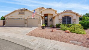 A two-story house with a garage, a front entrance, and a small garden area with rocks and plants. - Game Room, Backyard Oasis! Glendale Group Getaway (Glendale)