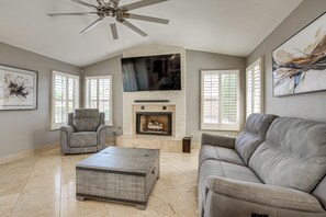 A living room with a fireplace, a ceiling fan, a sofa, a recliner, and a coffee table. - Game Room, Backyard Oasis! Glendale Group Getaway (Glendale)