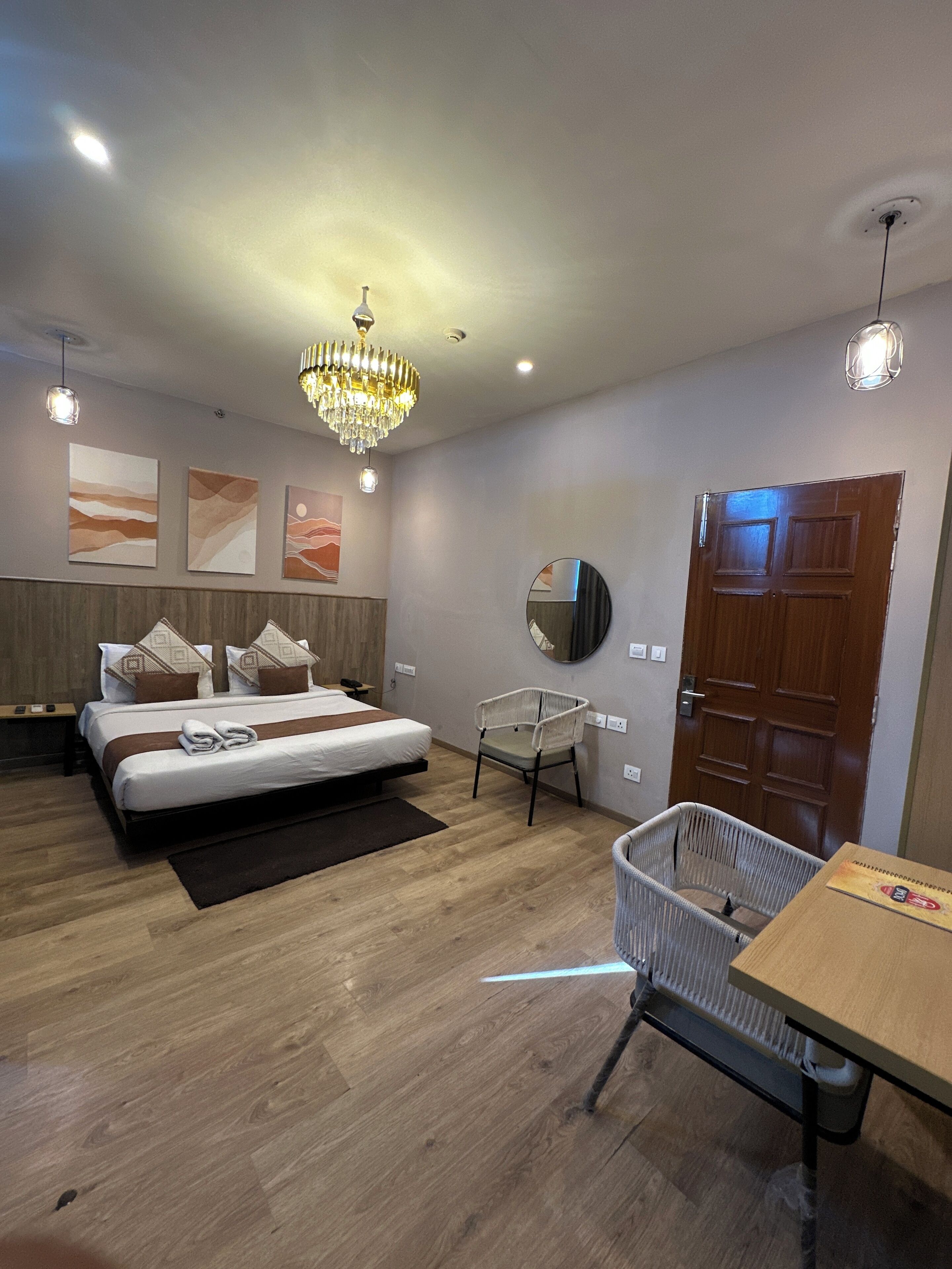 Quarto moderno com cama, cadeira, mesa e porta.