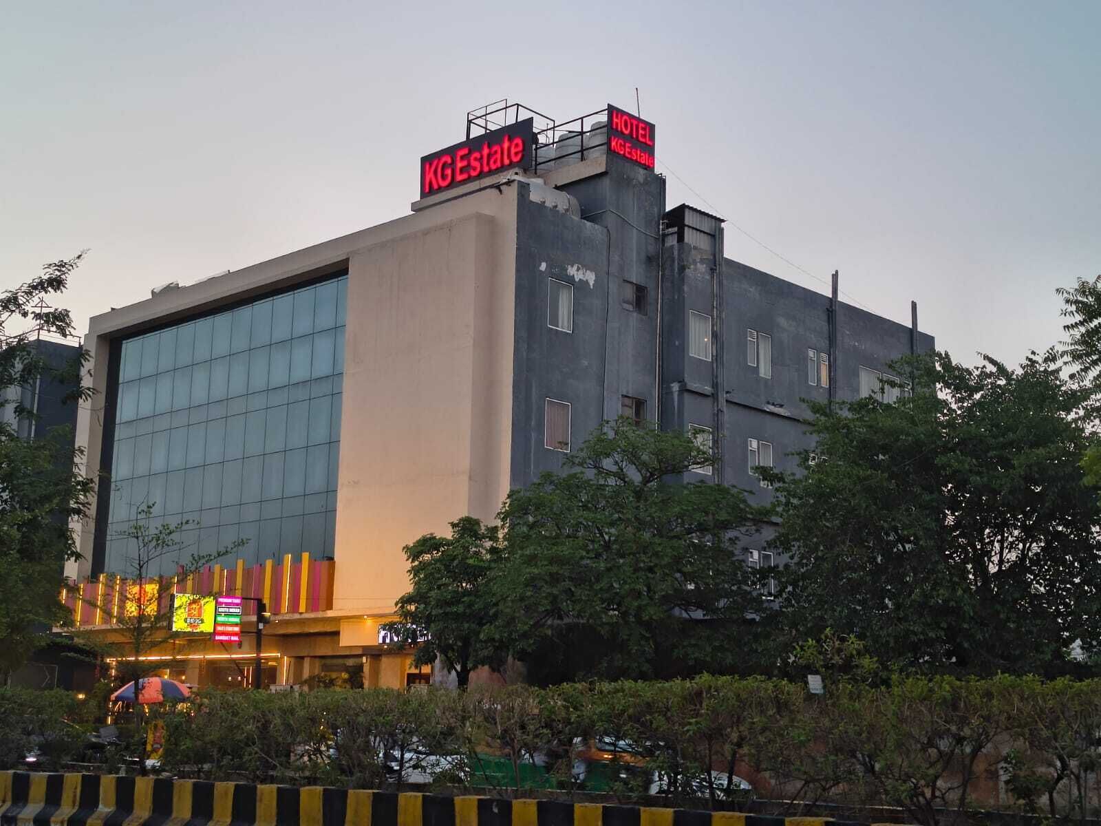 A hotel with a modern facade, large windows, and signage for KG Estate.