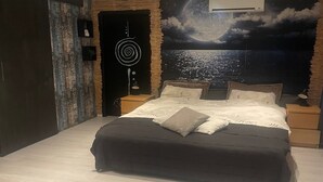 Ein Schlafzimmer mit Bett, Nachttischen, einer Wandmalerei und einer Tür.