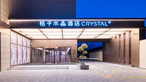 Ein Hotel Eingang mit einem Schild mit dem Schriftzug 'Crystal' und einem modernen Design.