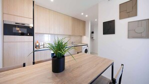 A modern kitchen with wooden cabinets, a built-in oven, a sink, and a countertop with a potted plant. - Charming apartment - 2BDR/6P - Saint Tropez/Port (Saint-Tropez)