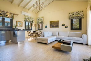 A spacious living area with a sofa, coffee table, dining table, and kitchen area. - Orion Luxury Villa, Estrellas Luxury Villas (Kefalonia)
