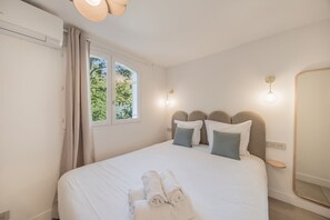 A bedroom with a bed, a window with curtains, a bedside table, and a mirror. - 6P apartment in a Citadelle /POOL - Saint-Tropez (Saint-Tropez)