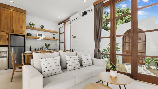 A modern kitchen with wooden cabinets, a built-in oven, and a refrigerator. - Calyra Villa by Kozystay - Ungasan (Ungasan)