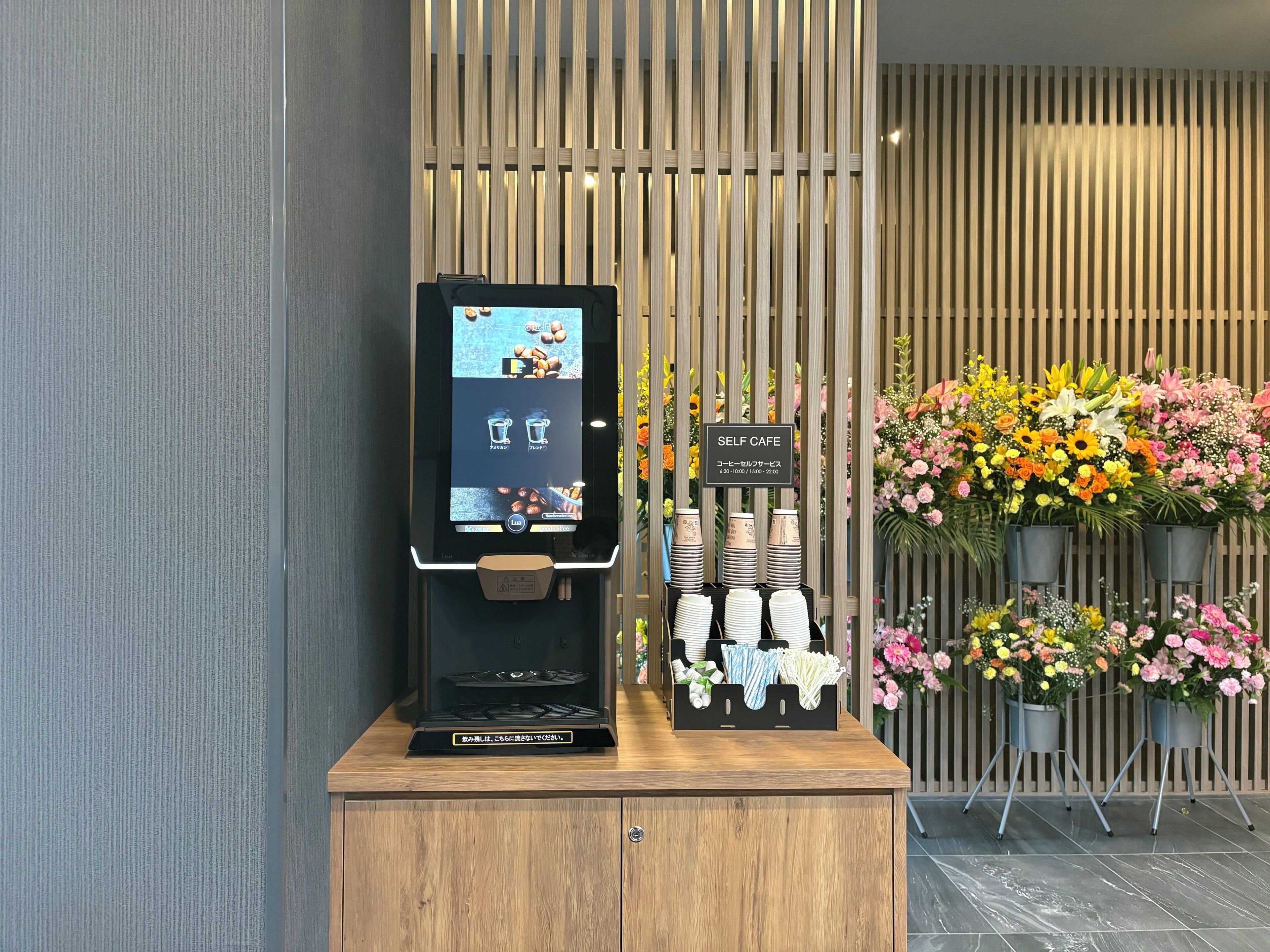 A self-service kiosk, a wooden cabinet, and a display of tableware.