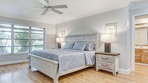 A bedroom with a bed, bedside tables, a ceiling fan, and a window with blinds. - Golf Course Getaway! Port St Lucie Home w/ Lanai (Port St. Lucie)
