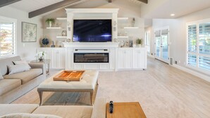 A spacious living room with a large flat-screen TV, a fireplace, and a ceiling fan. - 8 Mi to Downtown Modesto! Poolside Escape (Ripon)