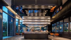 Eine moderne Bar mit einer zentralen Insel, Sitzgelegenheiten und großen Fenstern.