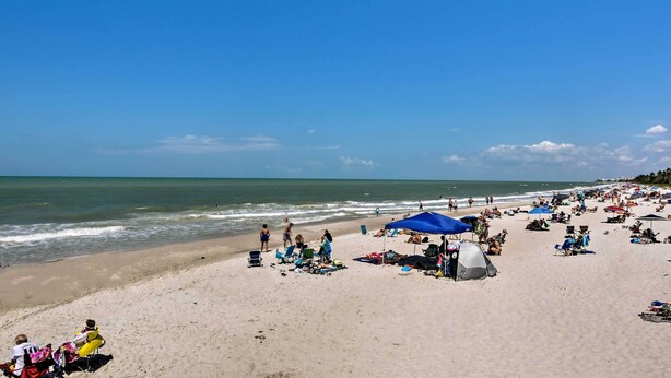 A crowded beach with people sunbathing, tents, and beach chairs. - Poolside Fun, Ocean Strolls! Naples Beach Getaway (Naples)